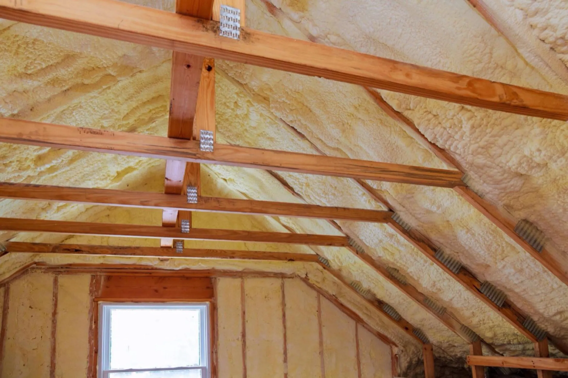 Attic roof deck insulated with spray foam between the rafters